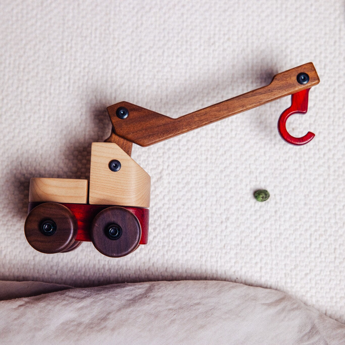 Walnut & Maple Crane from above on a cream textured throw, walnut jib and red padauk hook
