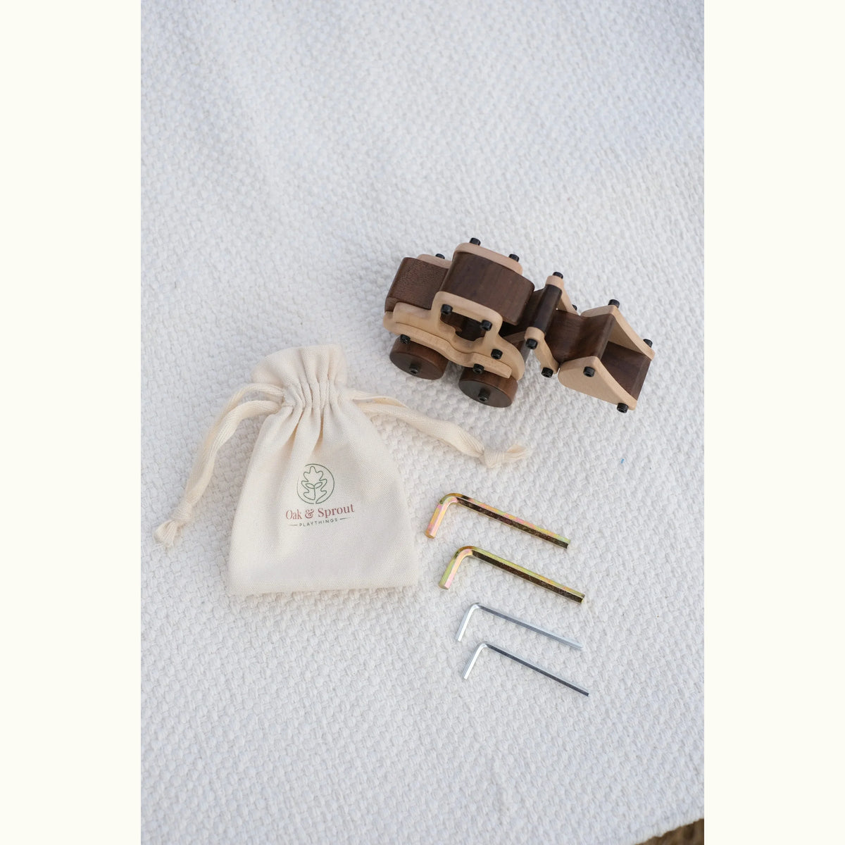 Maple Digger toy, hex keys, and branded pouch laid flat — maple body with walnut wheels and rear sections