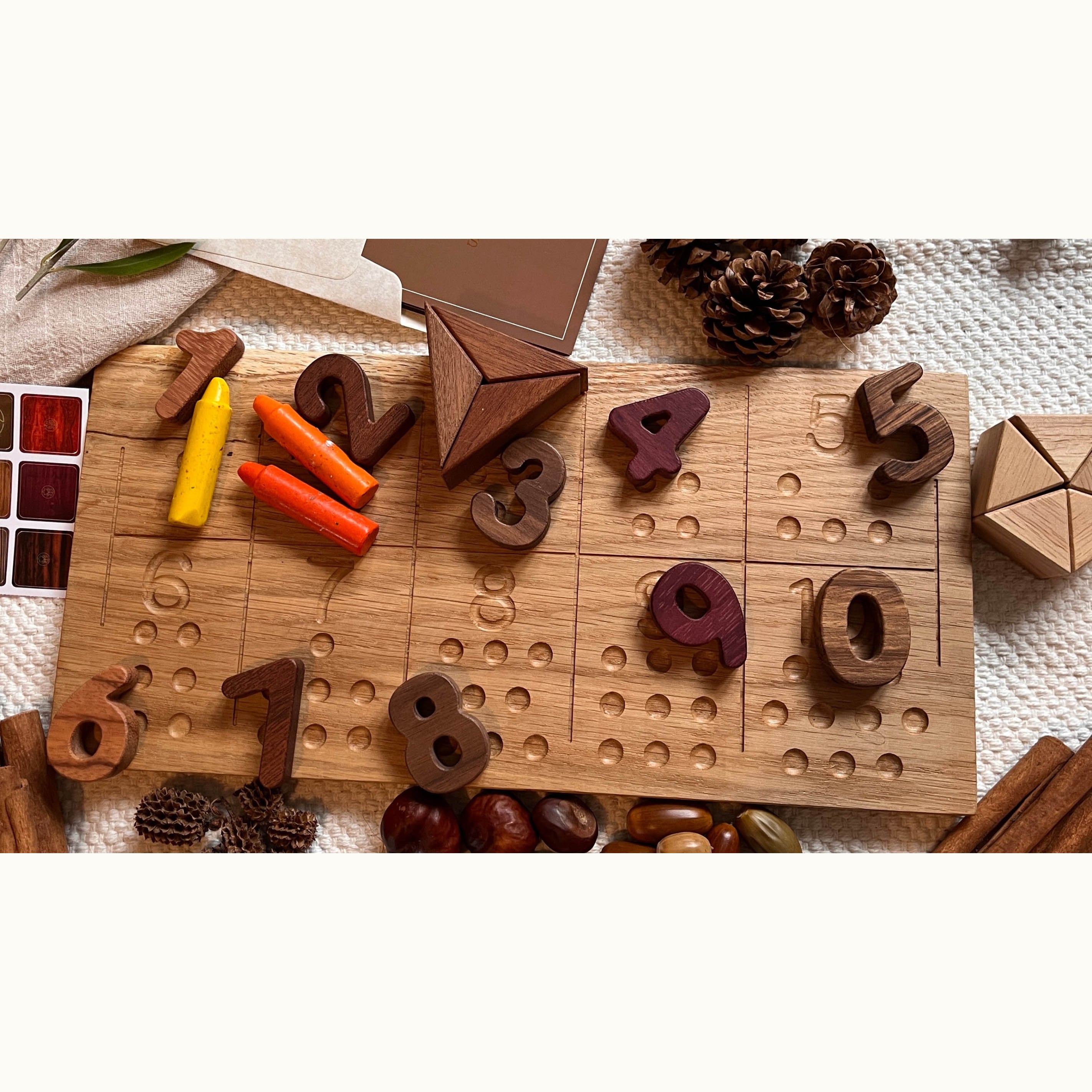 Numbers Tracing & Balls oak board with scattered walnut and purpleheart number pieces 1–10, styled with autumn nature props