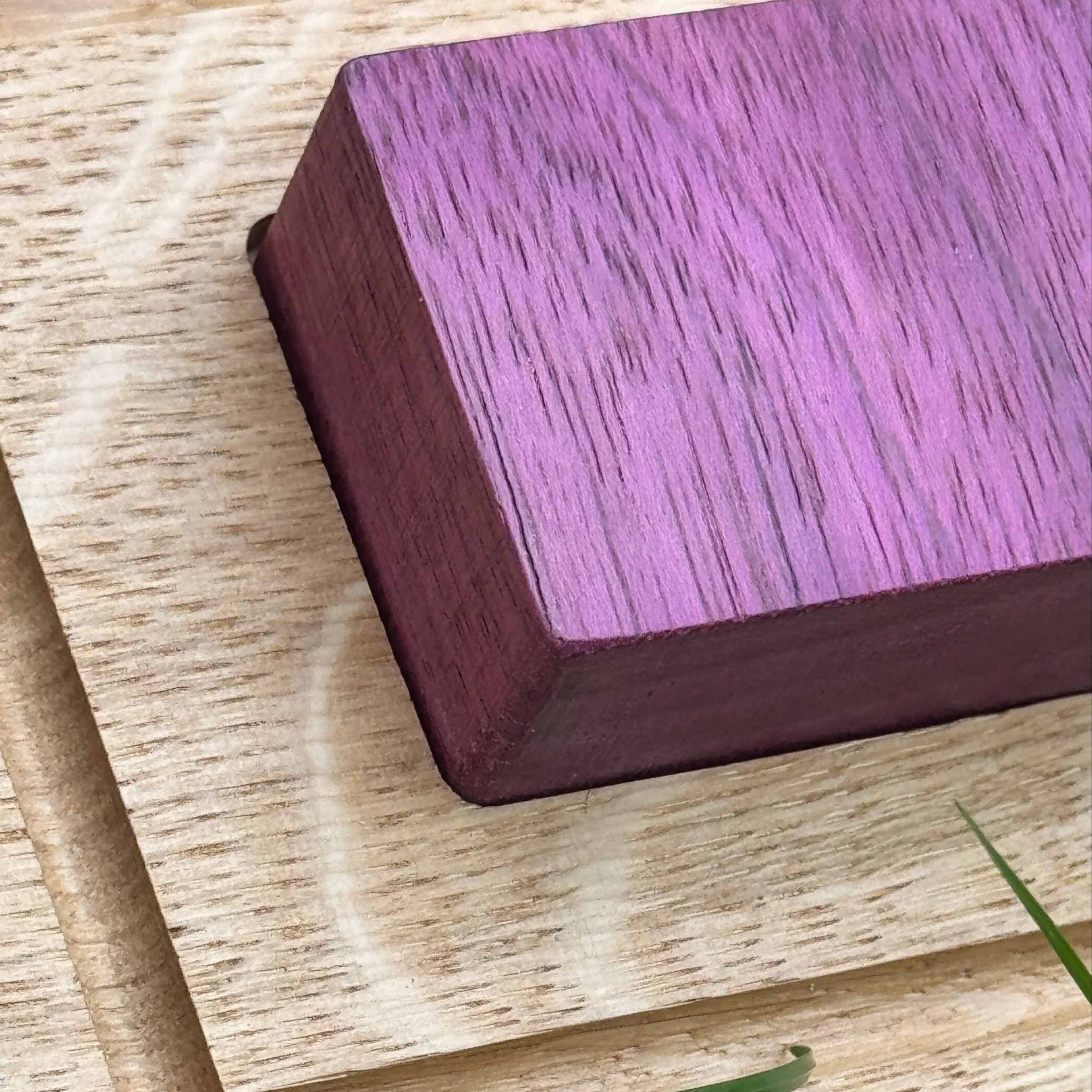 Trace & Place: close-up of a natural Purpleheart tracing piece resting on the Oak board, showing vivid violet grain and bevel