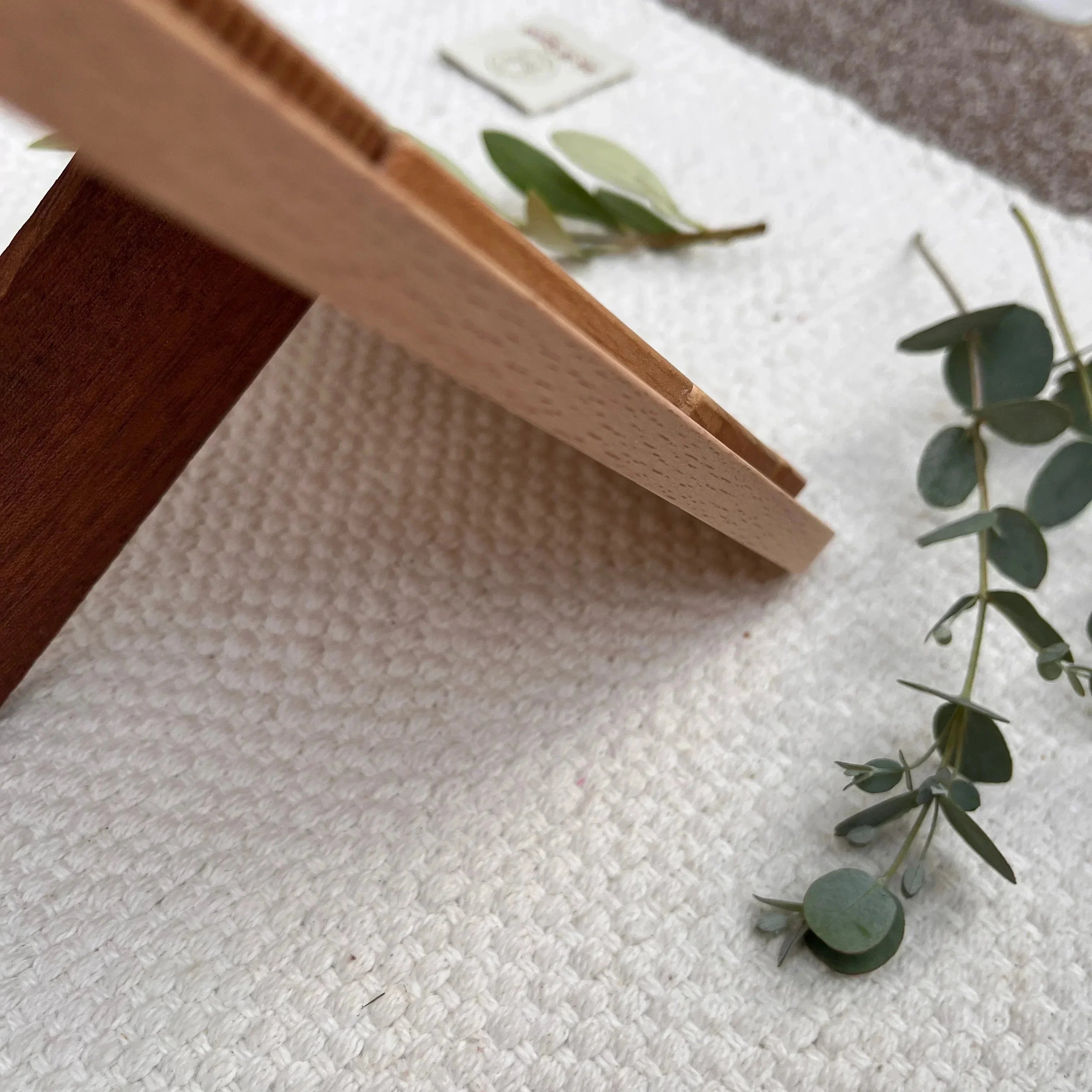 Sky Bloom puzzle beech frame underside detail showing natural grain and walnut piece on cream linen