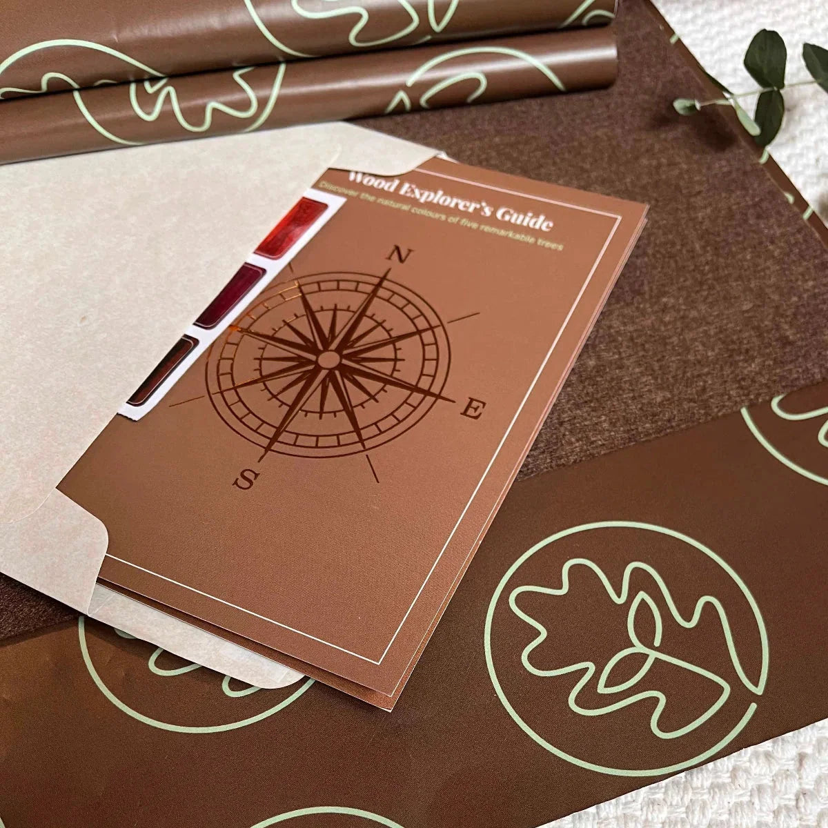 Alphabet Puzzle packaging: kraft envelope, Wood Explorer's Guide booklet, purpleheart wood swatch card, and oak leaf gift wra