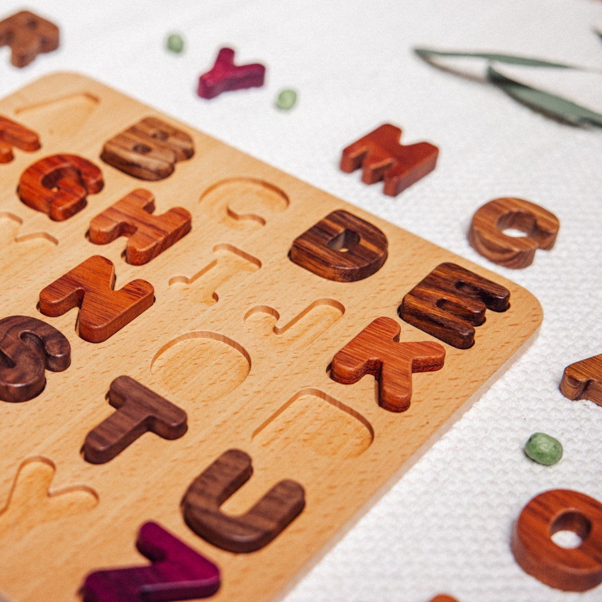 Wooden alphabet puzzle with letters on a white surface