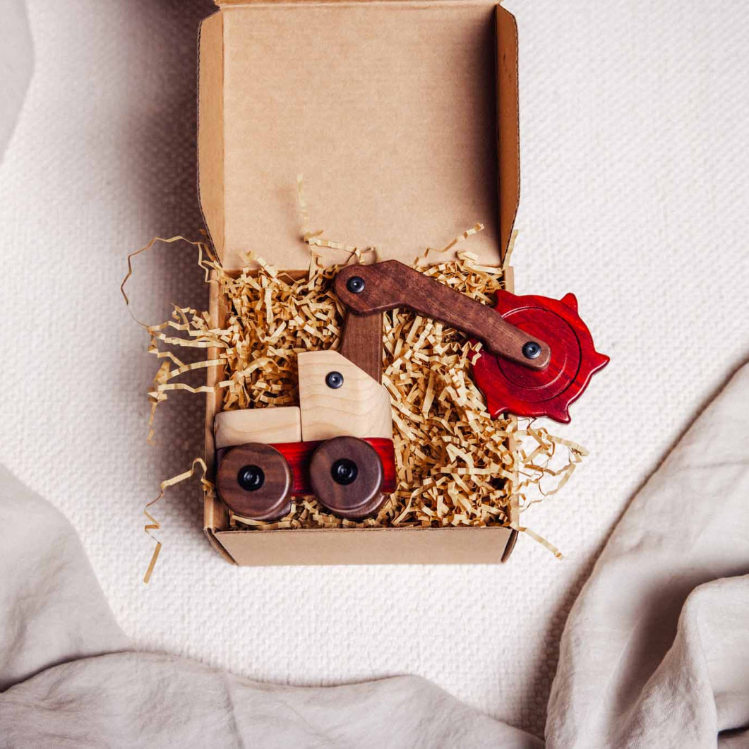 Toy trench digger in a cardboard box on a light fabric background