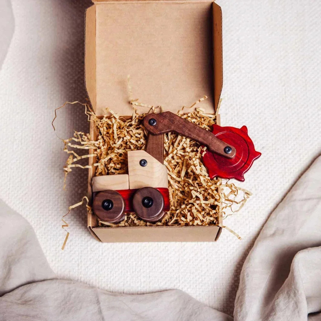 Complete Wooden Vehicles Set crane toy unboxed in kraft paper, showing maple cab, walnut wheels, and padauk base