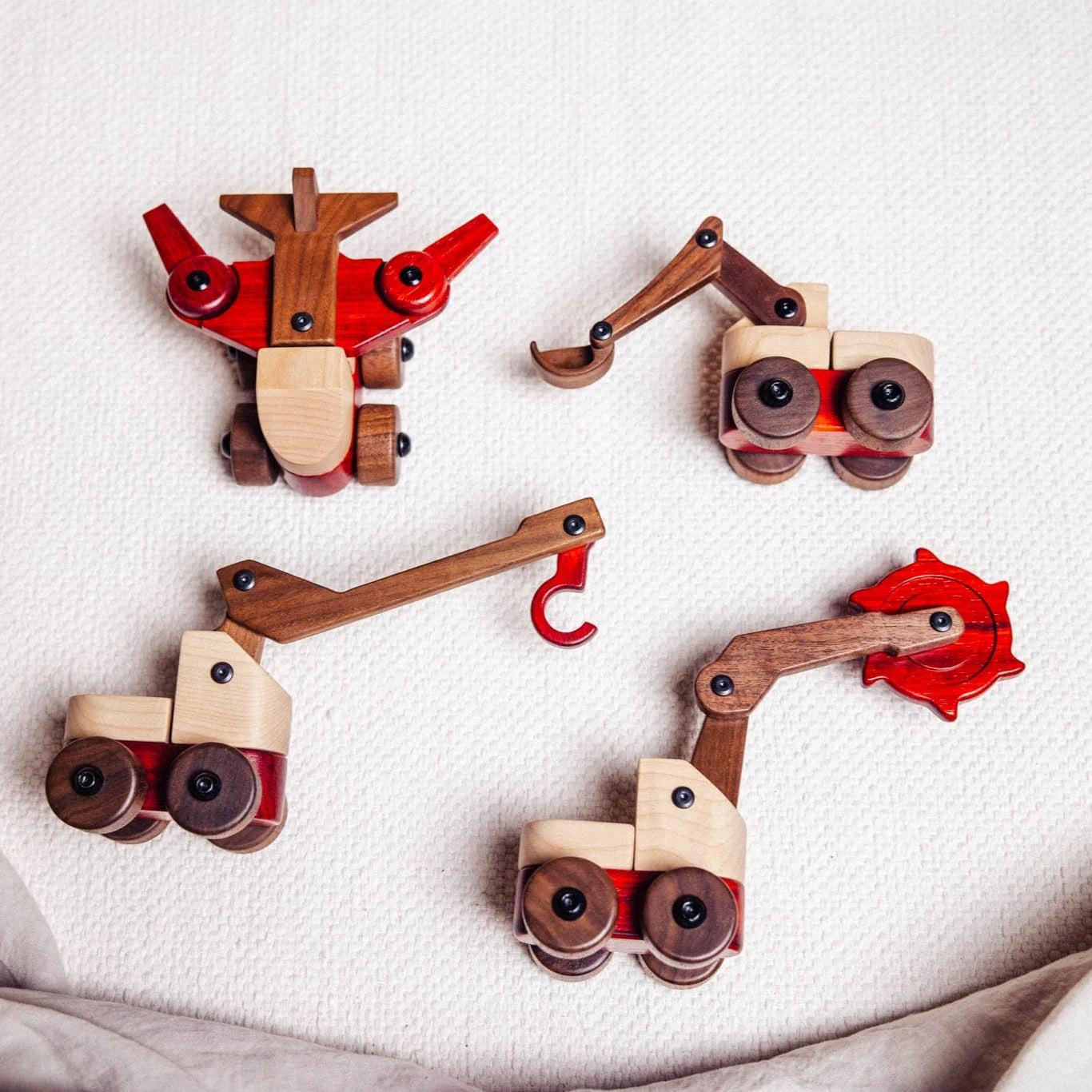 Maple Padauk Walnut Excavator toy shown in four construction vehicle configurations on cream linen flatlay