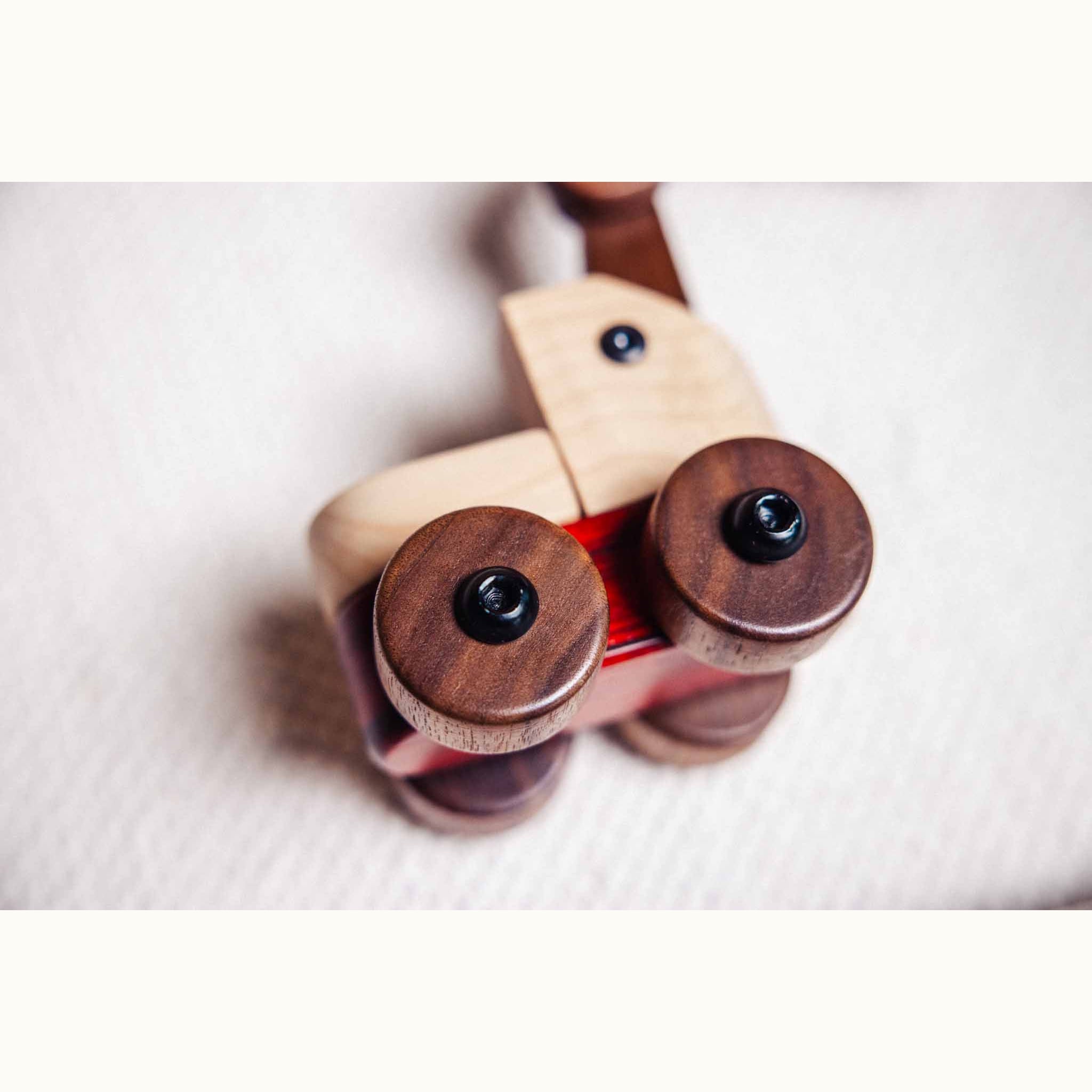 Padauk & Maple Trench Digger front axle close-up: walnut wheels with bolt fixings, maple body, padauk chassis strip