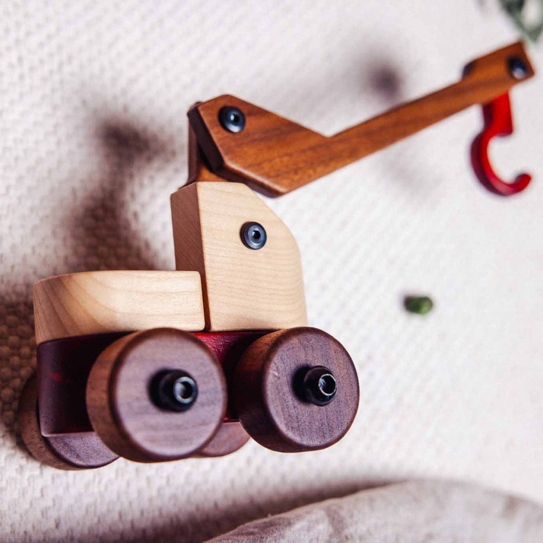 Wooden toy crane on a textured surface