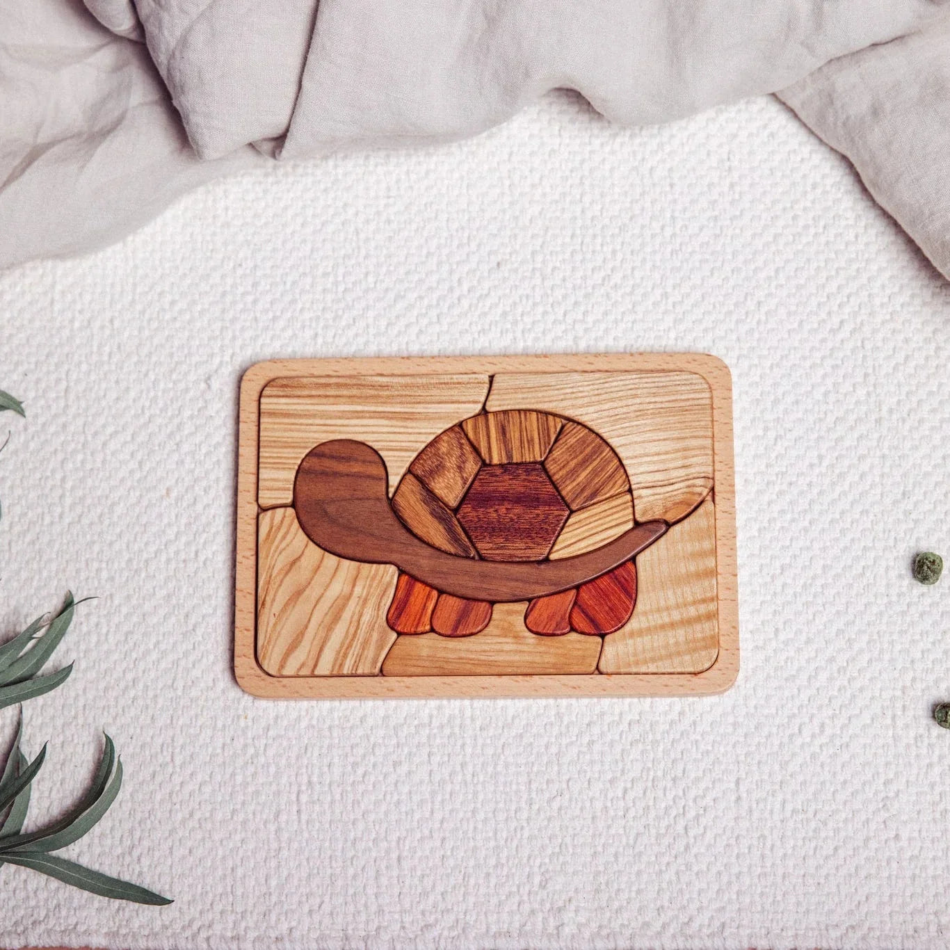 Shelly Slow turtle puzzle fully assembled, flat-lay on waffle playmat, showing walnut, tigerwood, zebrano and mahogany tones