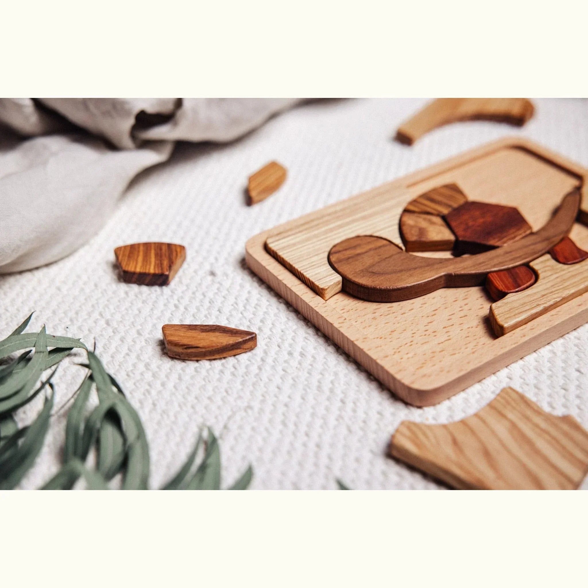 Shelly Slow turtle puzzle partially assembled on waffle-knit playmat, walnut head and mahogany shell pieces visible mid-play
