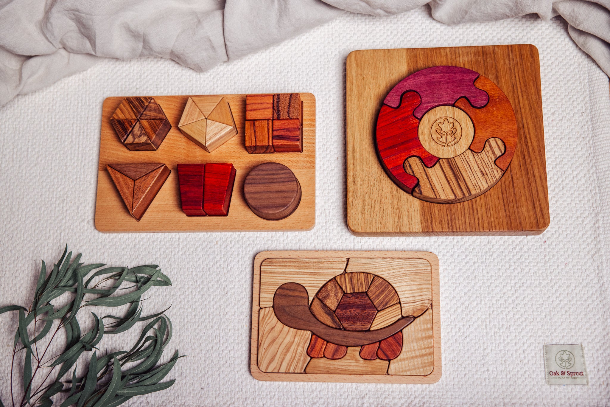 Three wooden puzzle pieces on a textured surface with a plant in the corner.