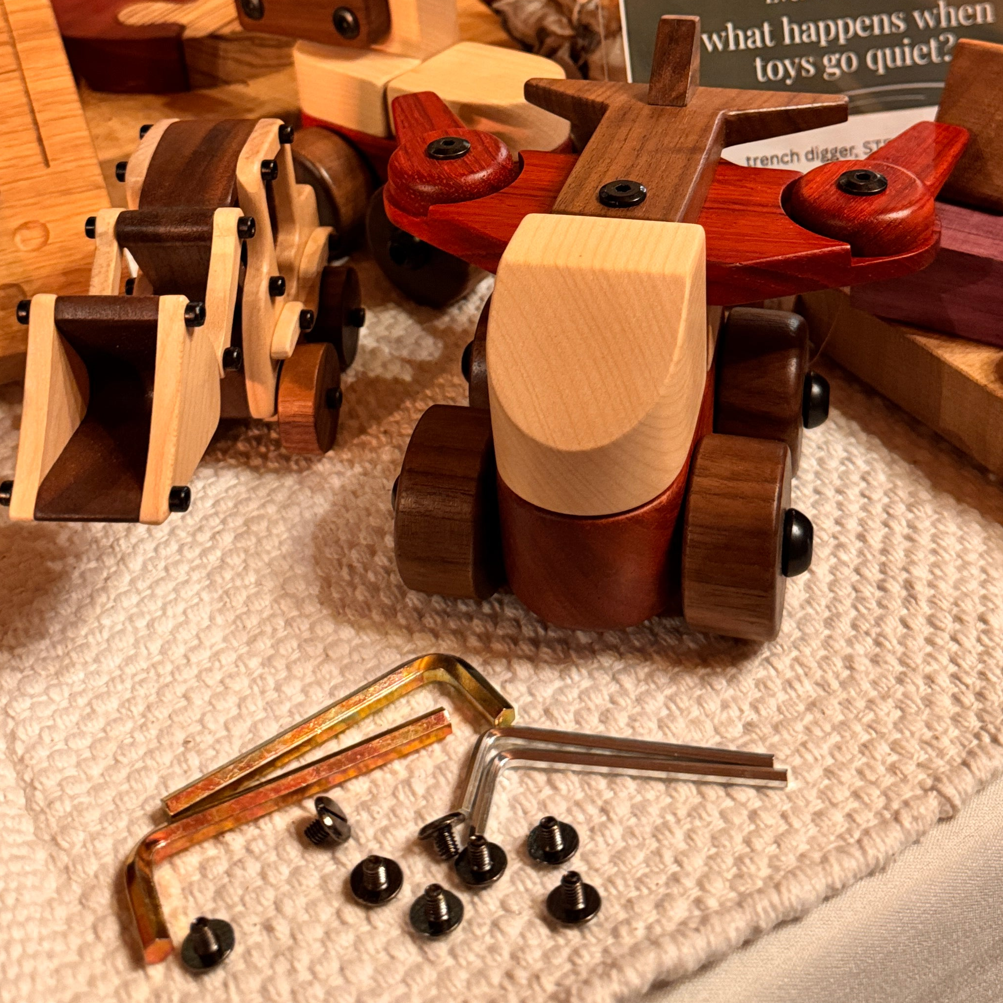 Complete Wooden Vehicles Set partially dismantled with hex keys and screws on linen — Padauk, Maple, and Walnut components