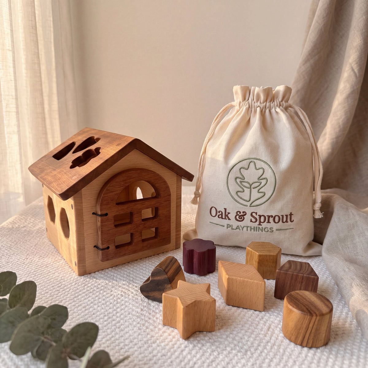 Shape Sorter House in beech and mahogany with purpleheart, movingui, and zebrano blocks and branded cotton bag on cream
