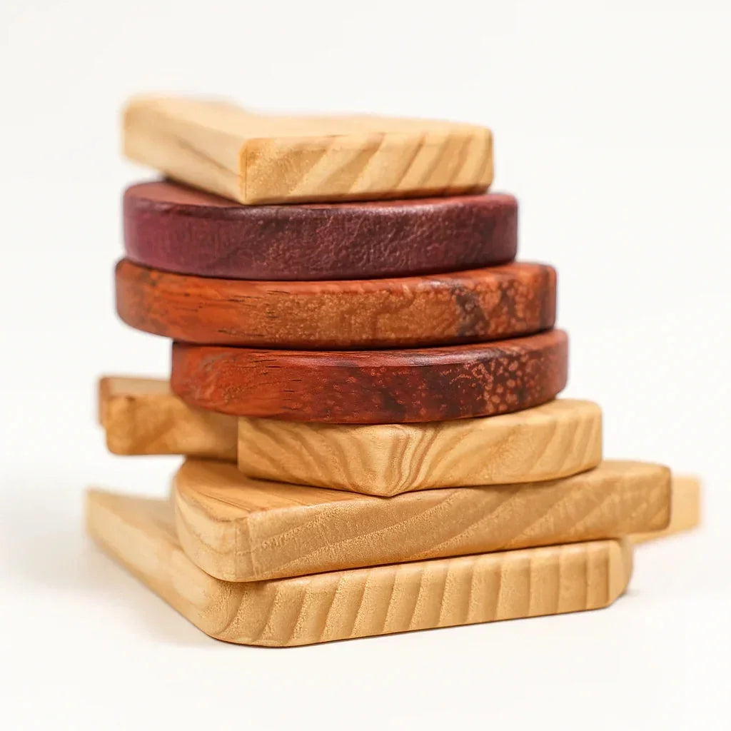 Sweet Scoops puzzle pieces loosely stacked — pale Tigerwood base, rich Padauk and Purpleheart scoop discs, white background