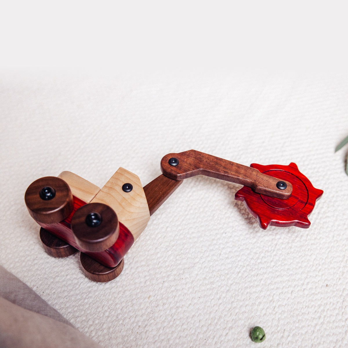 Padauk & Maple Trench Digger from above on a cream textured throw, walnut arm and padauk cutter wheel