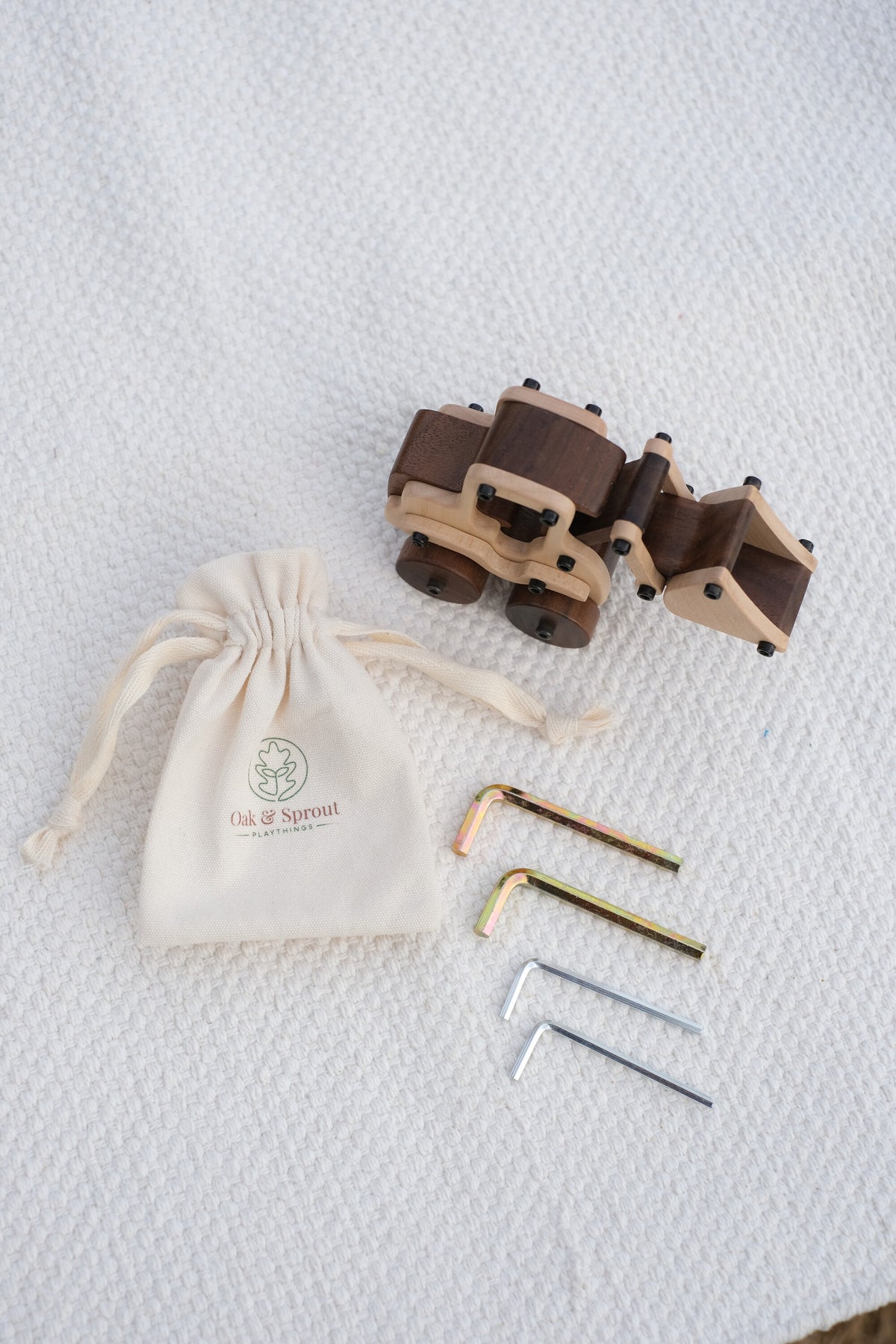 Maple Digger toy, hex keys, and branded pouch laid flat — maple body with walnut wheels and rear sections