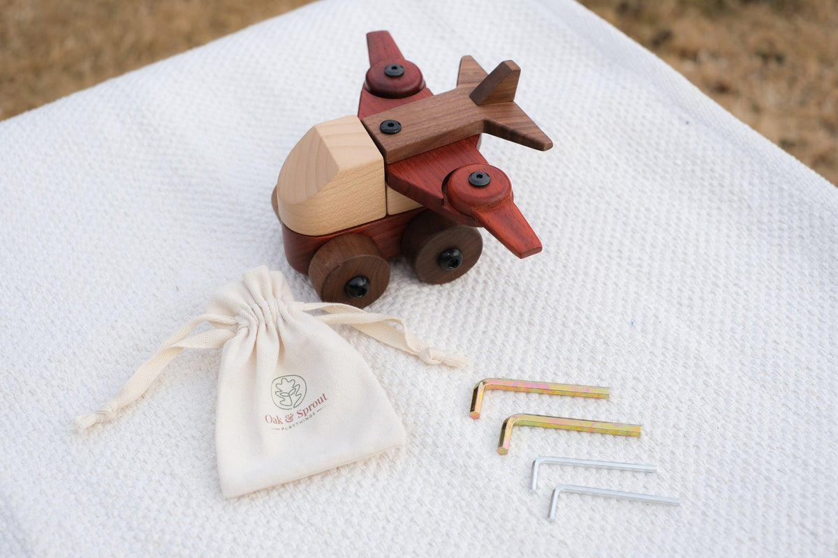 Walnut & Padauk Aeroplane with an Oak & Sprout cotton drawstring pouch and four child-size Allen keys on a white textured throw