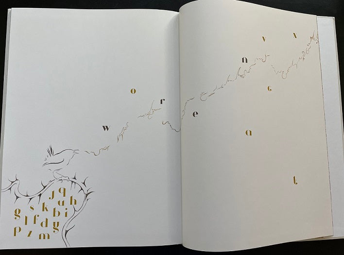 The Lost Words open book spread showing gold and black letterforms, ink illustrations of thorny branches and a bird across