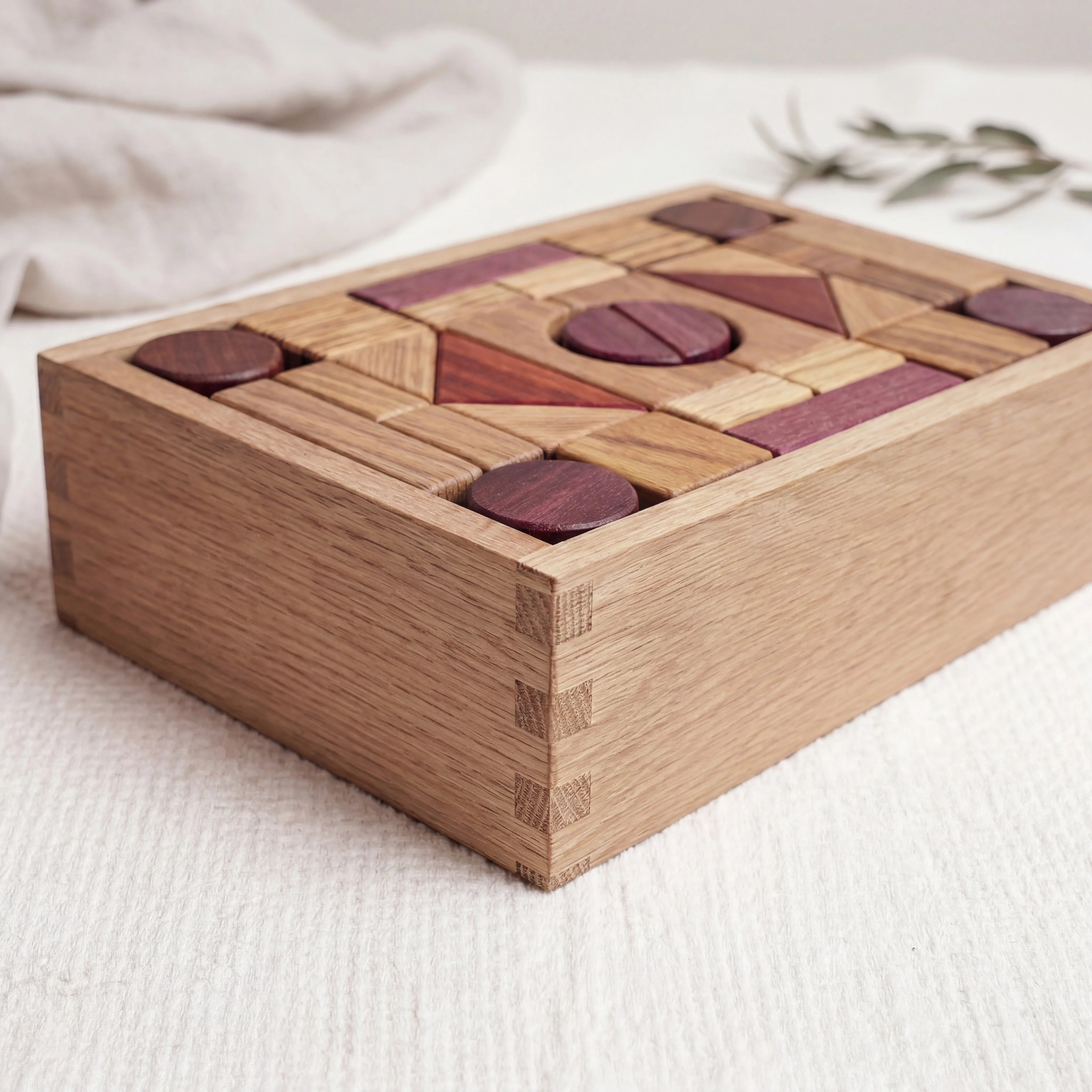 60-piece exotic hardwood building blocks packed in dovetail oak tray, showing oak, purpleheart, padauk and zebrano pieces