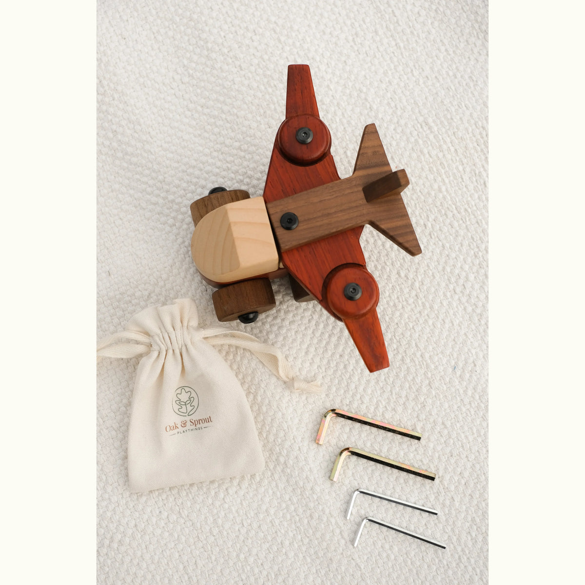 Walnut Padauk Maple aeroplane flat lay from above with cotton drawstring bag, branded packaging and three hex keys
