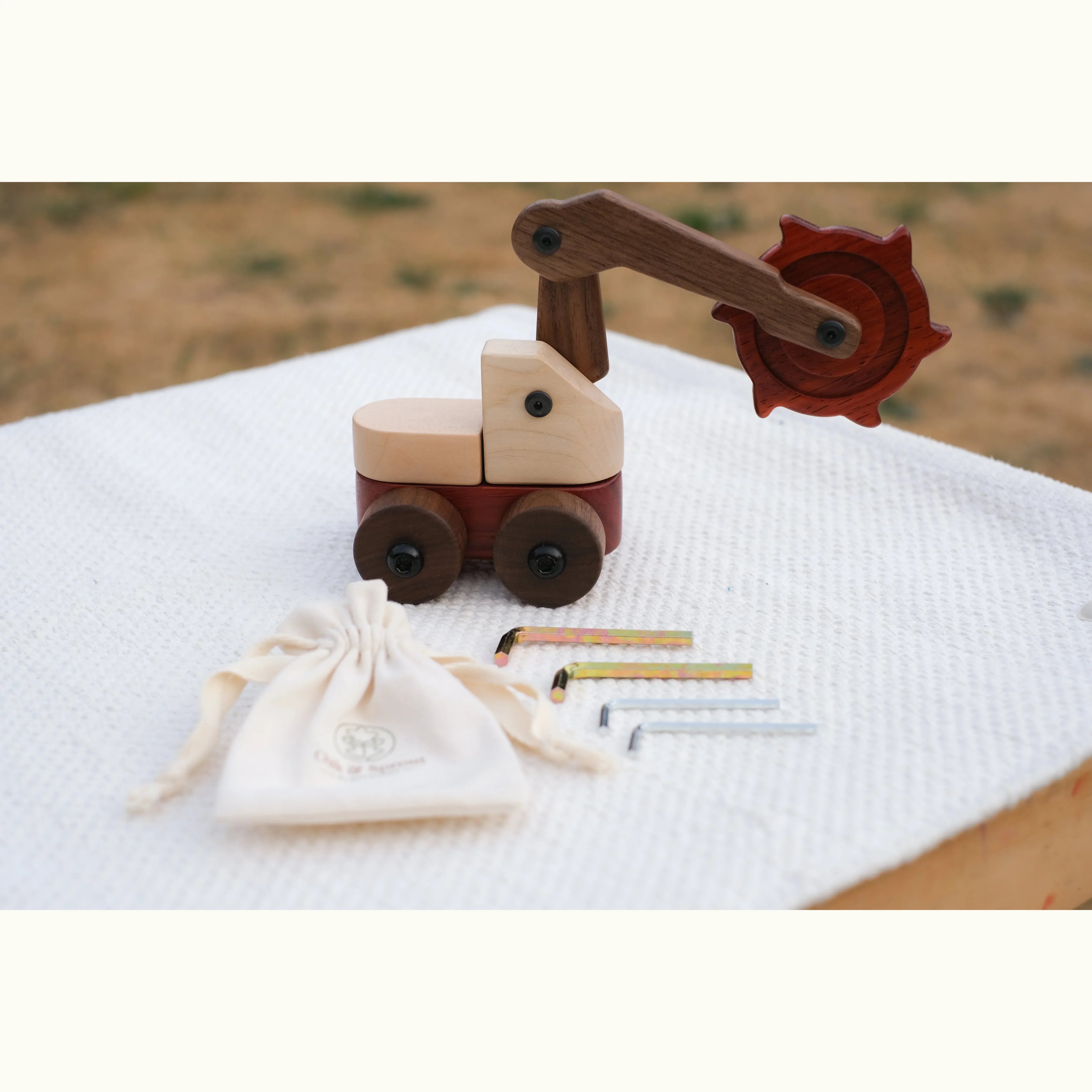 Padauk & Maple Trench Digger fully assembled with Allen keys, screws, and branded cotton drawstring pouch showing maple,