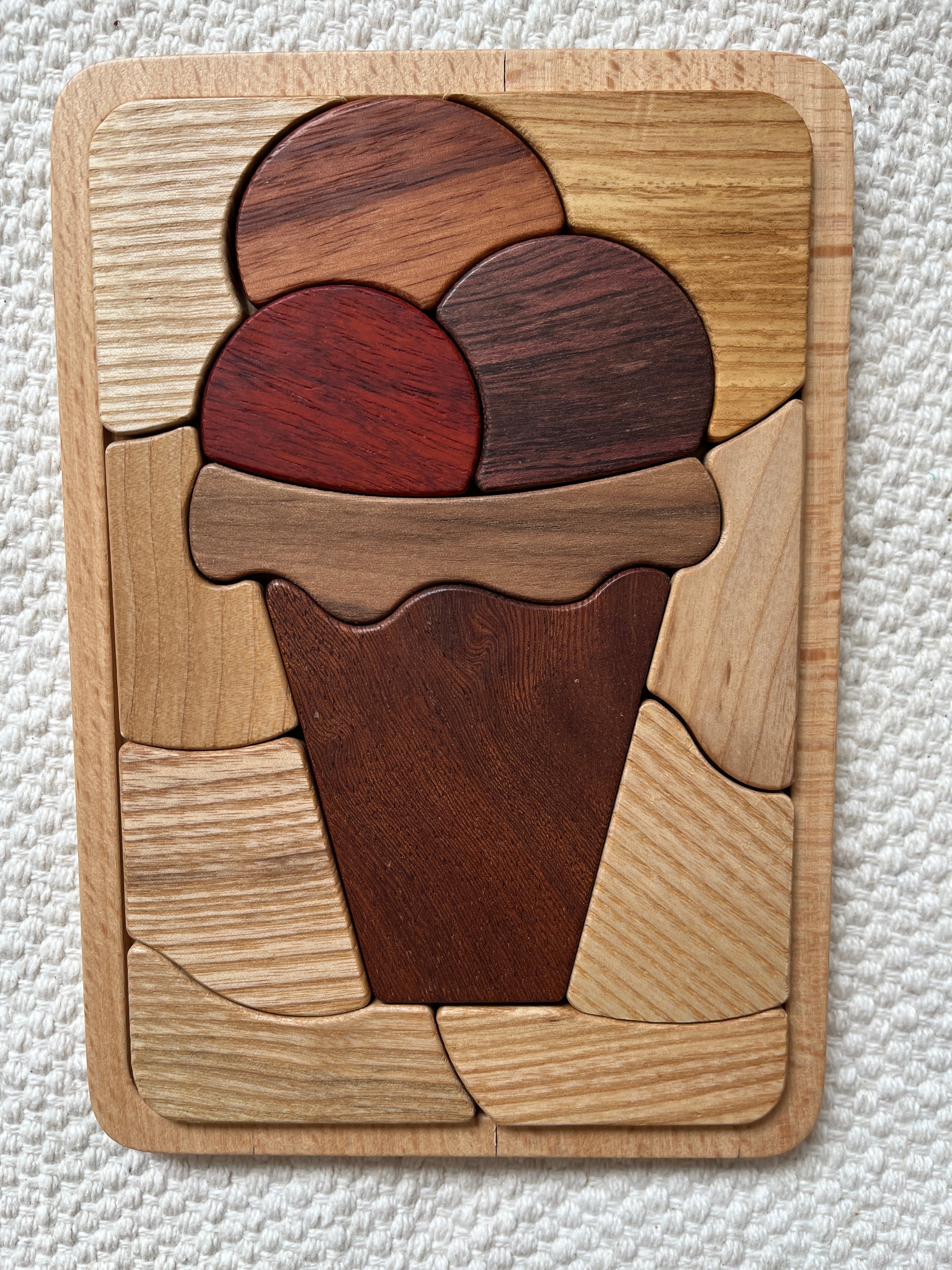 Wooden puzzle with various wooden pieces on a textured white background