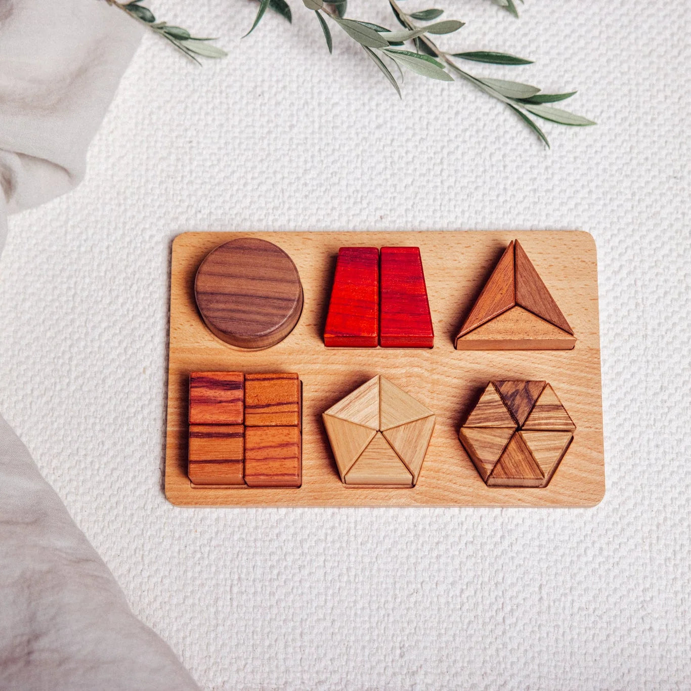 Geo Nest puzzle assembled flat-lay, six shapes in walnut, padauk, zebrano, tigerwood, mahogany and rubberwood