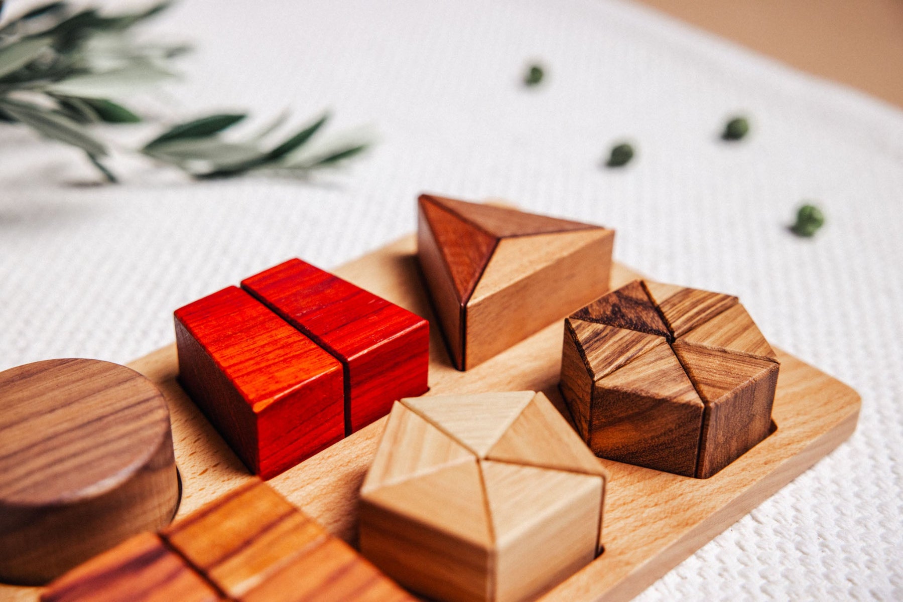 Wooden geometric puzzle pieces on a wooden board with a light background