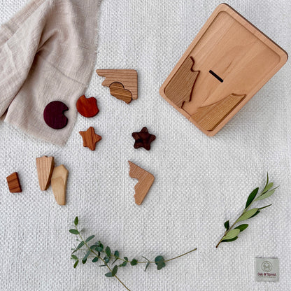Beech shape-sorter with naturally coloured wood pieces (Padauk, Purpleheart, Zebrano) on white cotton play mat – Oak & Sprout