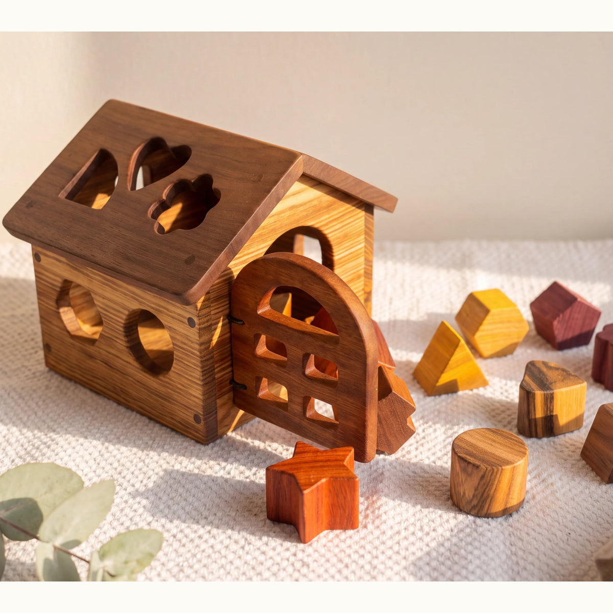 Shape Sorting House in Zebrano and Walnut, assembled with Padauk, Purpleheart, and Movingui sorting pieces scattered on linen