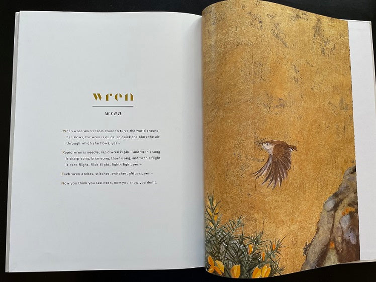 The Lost Words book open to the wren page, showing Robert Macfarlane's poem and Jackie Morris's golden wren illustration