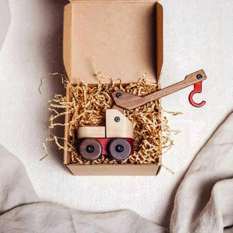 Oak & Sprout crane truck toy in kraft gift box with shredded paper, maple cab, walnut crane arm, padauk chassis and hook